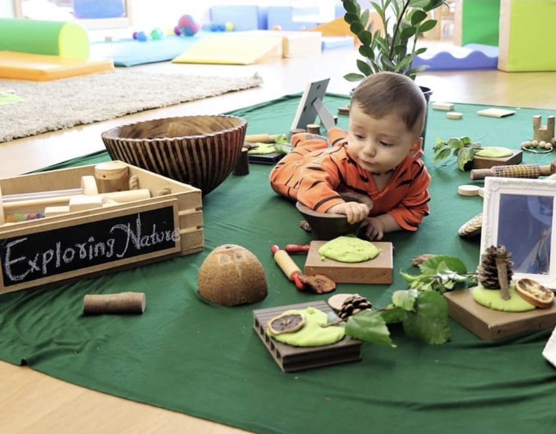 Pine cones, leaves and natural play dough offered for exploration