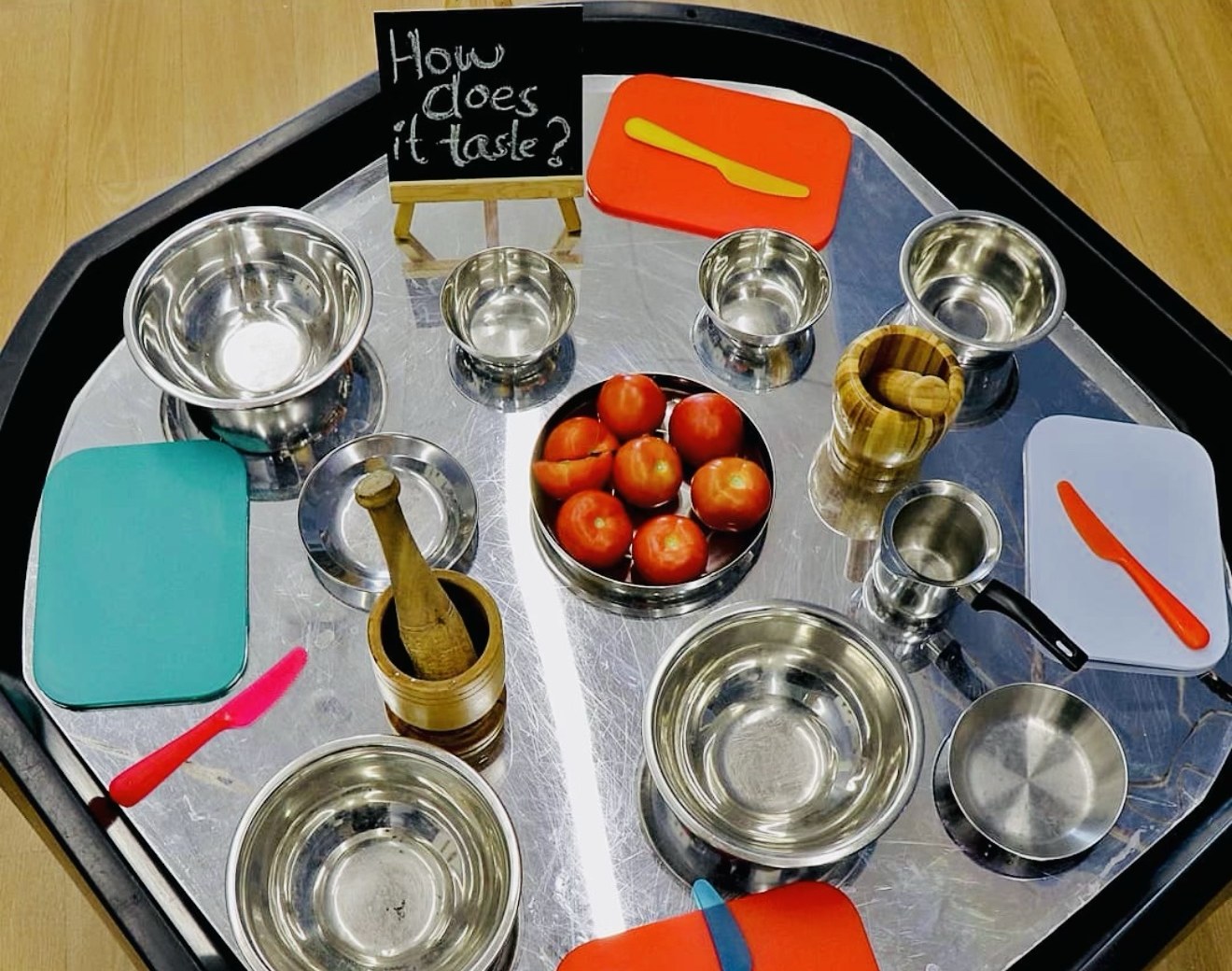 Real tomatoes and everyday kitchen tools invite children to taste, mash and talk